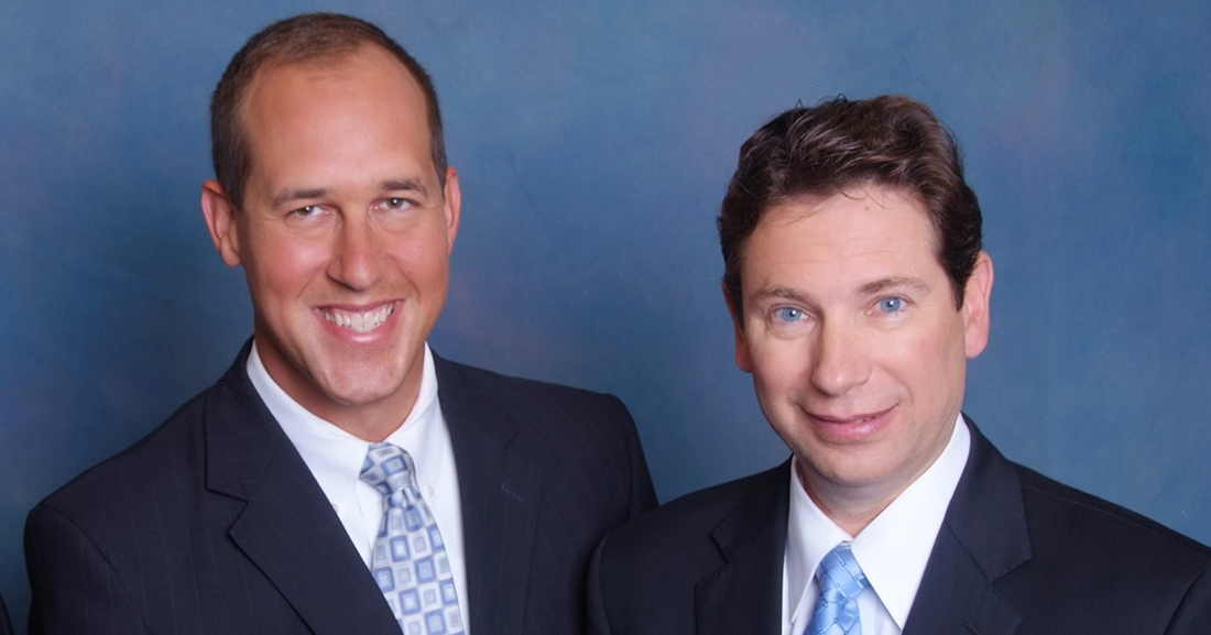 a couple of men in suits posing for a picture