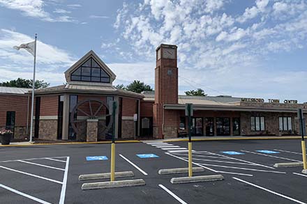 an empty parking lot with a clock tower in the background