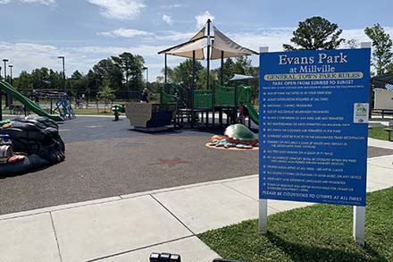 a blue sign sitting in the middle of a park