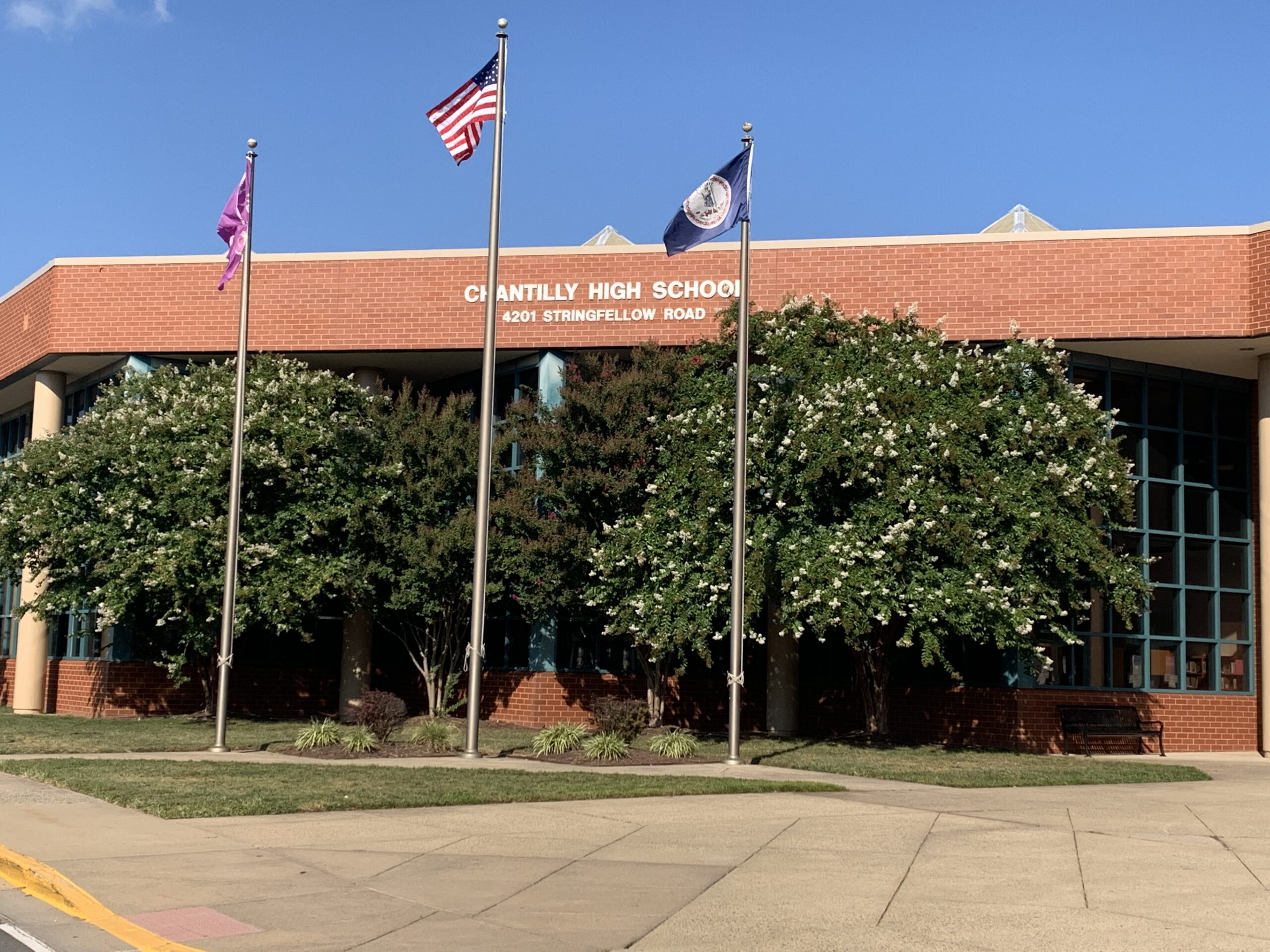 a school building with flags flying outside of it