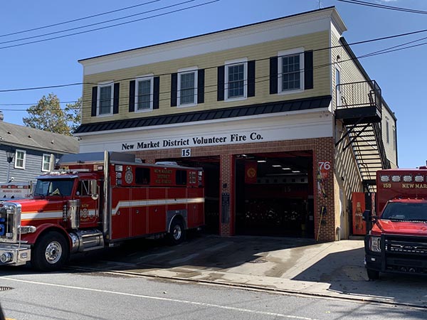 two fire trucks parked in front of a fire station