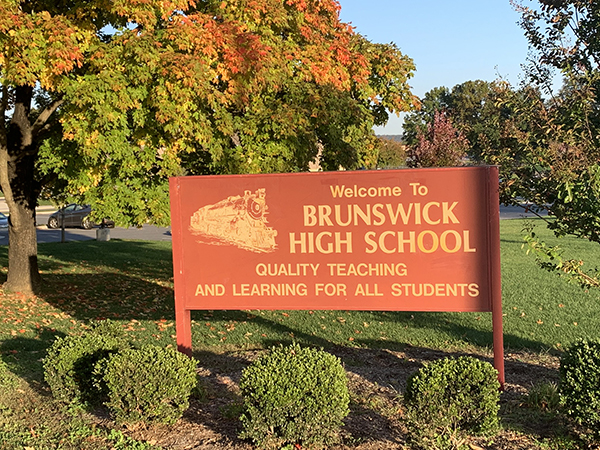 a welcome sign in front of some trees